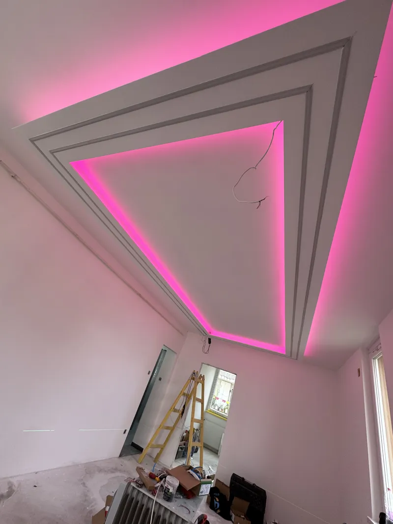 Álmennyezeti fényvályú rózsaszín RGB LED-világítással egy készülő szobában