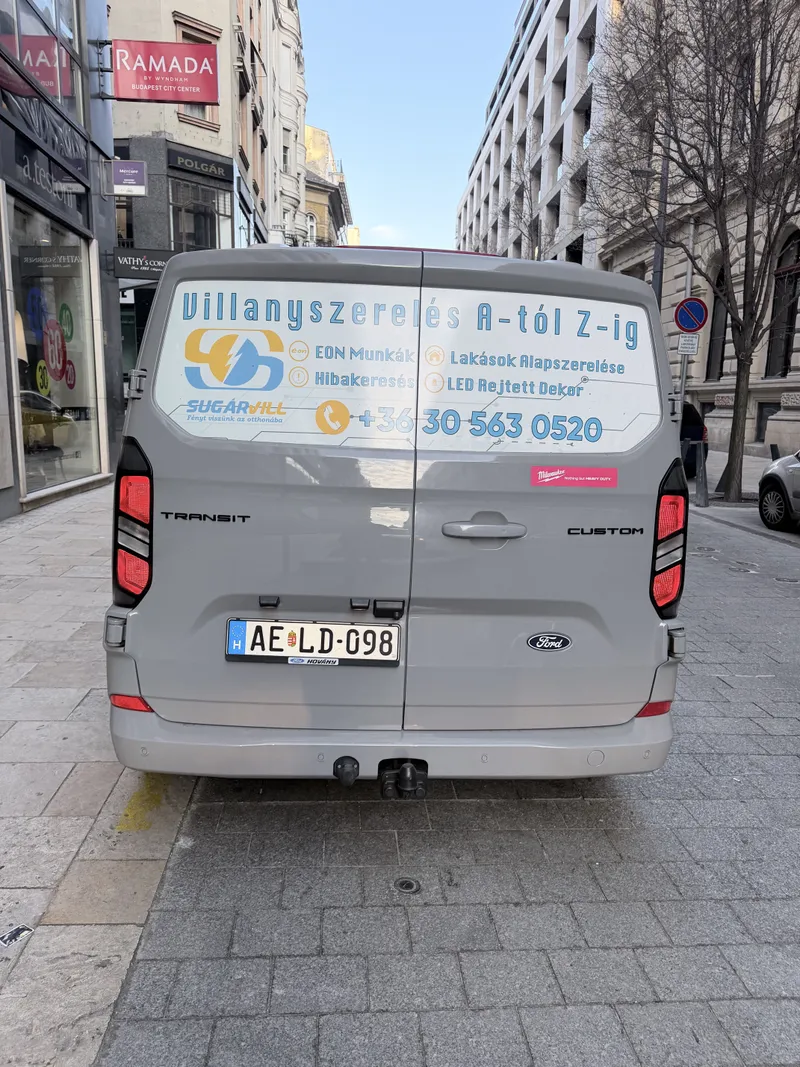 Céges furgon hátulja a szolgáltatásokat felsoroló matricával